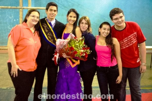 La nueva “Miss Garota Estudiantil” Hanna María Acevedo Mareco acompañada por su madre la señora Kelly Mareco Acevedo, el “Mister Garoto Estudiantil” Franco Pereira y un grupo de compañeros de la Escuela Anglo Mappe de Ponta Porã. (Foto: Lázaro González).