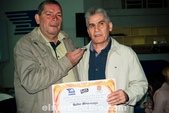 El popular cronista Genaro Rivas recibe el pergamino de reconocimiento representando a Radio Mburucuyá 980 AM de manos del vicepresidente de la Cámara de Industria y Comercio de Pedro Juan Caballero Khalil El Hague. (Foto: Diego Lozano).