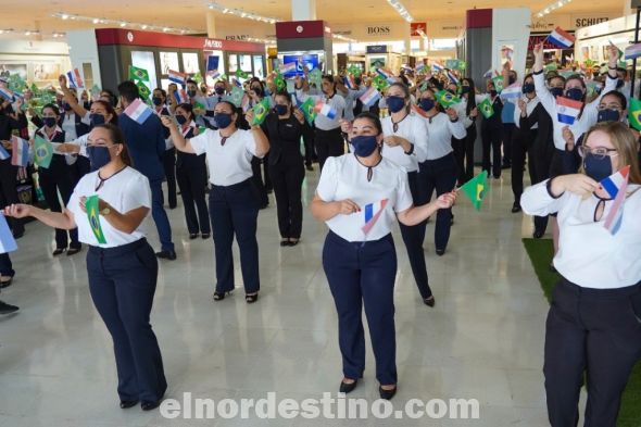 Colaboradores de Shopping China de Pedro Juan Caballero cantaron y agitaron banderas de Paraguay y Brasil al momento de abrir las puertas del local de ventas, como una nítida demostración de alegría por volver a sus puestos de trabajo. (Foto: Gacetilla de Shopping China).